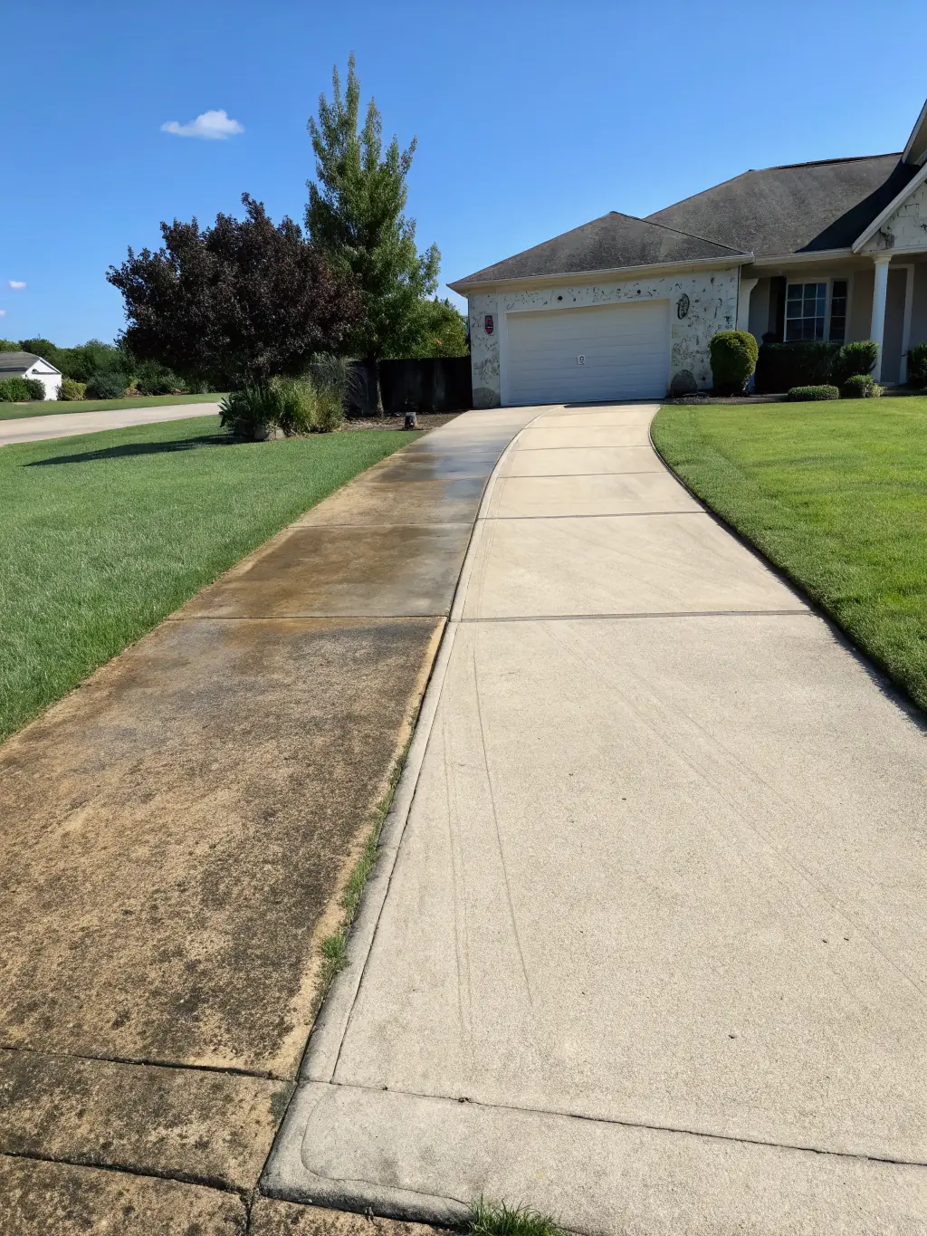 A before-and-after image showing a stained driveway transformed into a clean surface, showcasing the effectiveness of Florida Coast Power Washing LLC's driveway cleaning service.